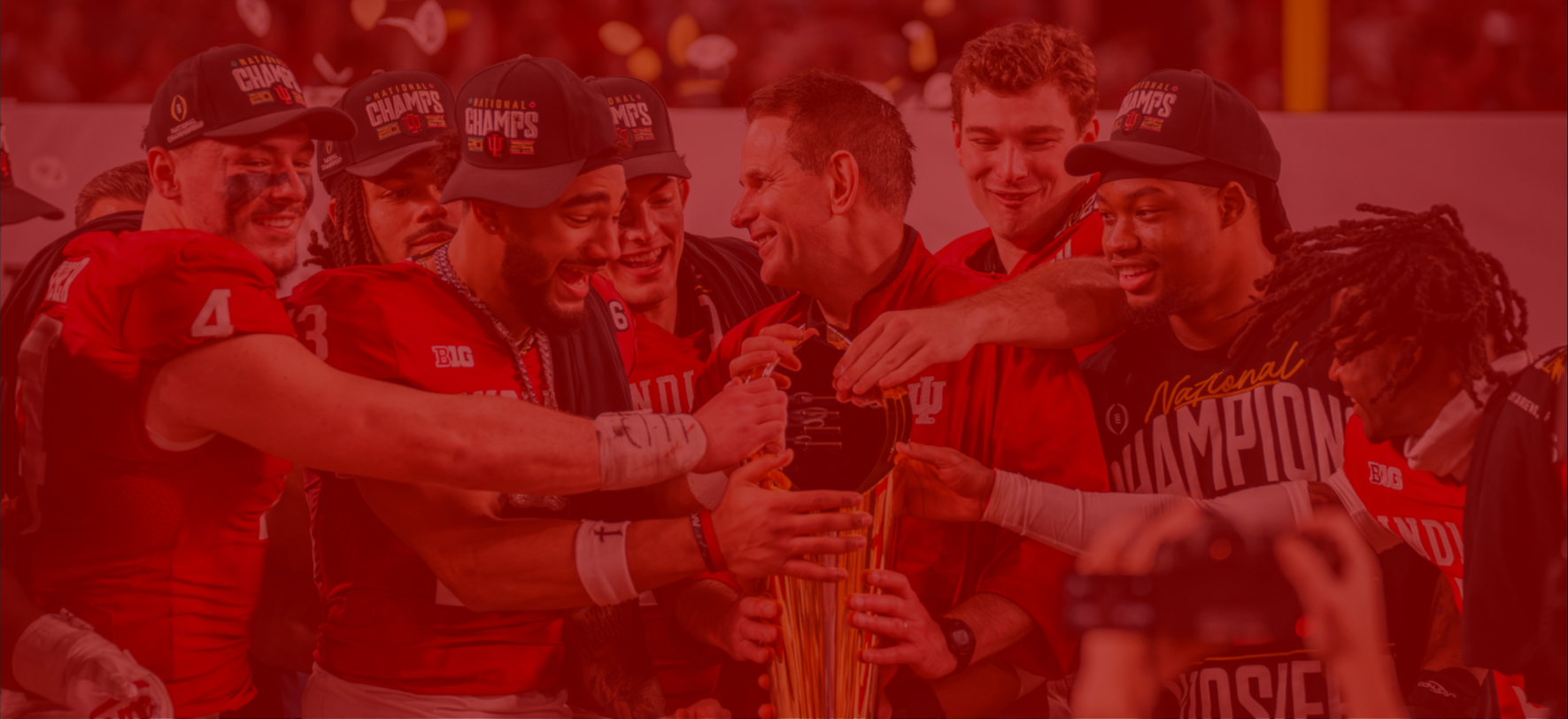 Team celebrating with a trophy, wearing championship hats.